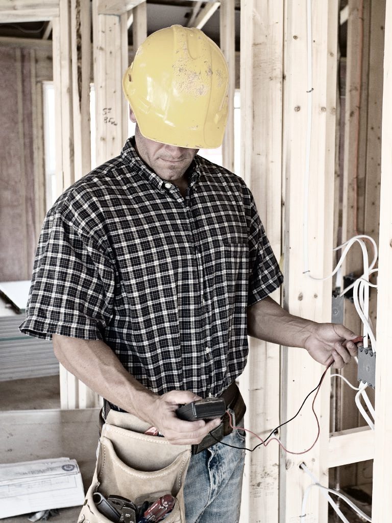 Handwerker prüft eine Stromleitung.